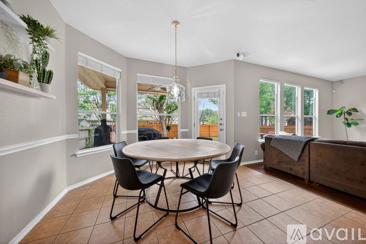 A dining room with a round table and chairs.