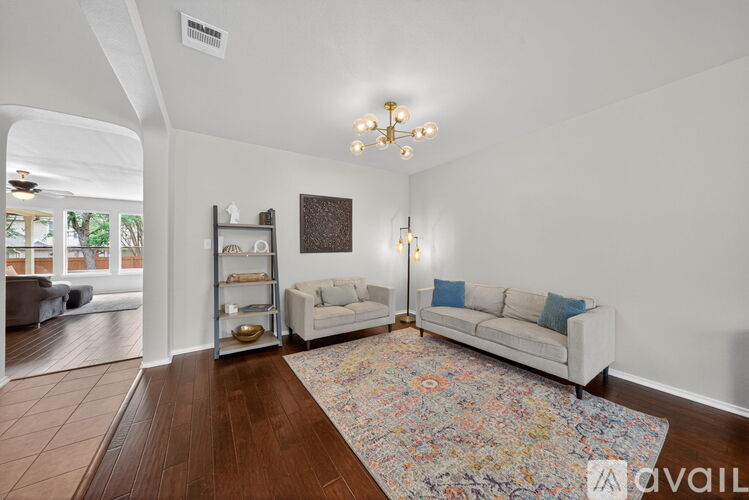 A living room with a white couch and a chandelier.