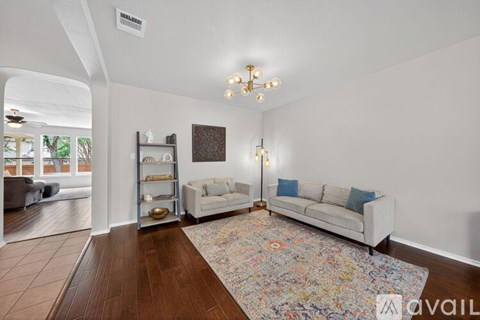 A living room with a white couch and a chandelier.