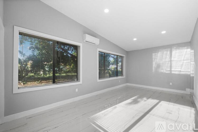 A spacious room with a large window and a floor heating system.