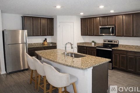 A kitchen with brown cabinets and a granite countertop.