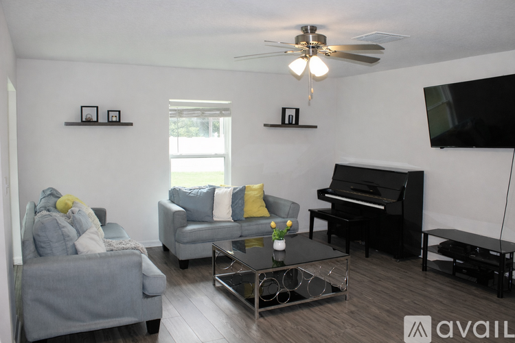 A living room with a piano and a television.