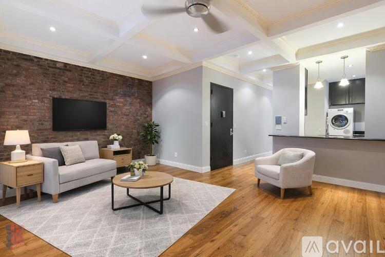 A living room with a brick wall and a flat screen TV.