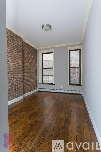 A room with wooden floors and a brick wall.