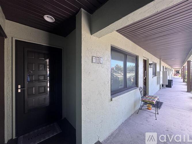 A black door is on the left and a chair is on the right.