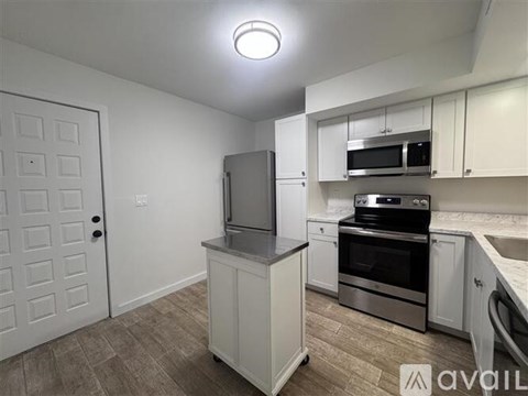 A kitchen with white cabinets and stainless steel appliances.