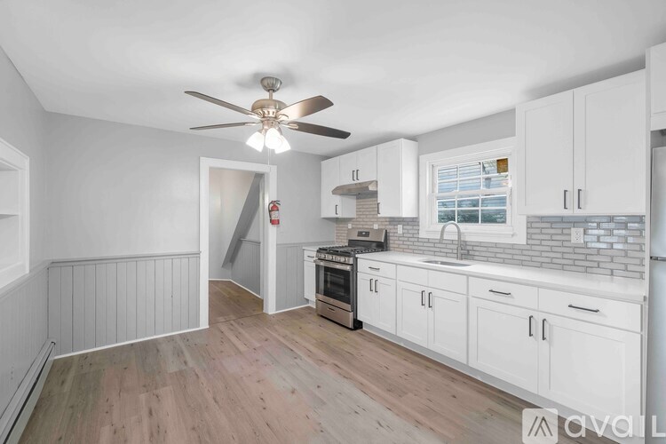 A kitchen with white cabinets and a wooden floor.