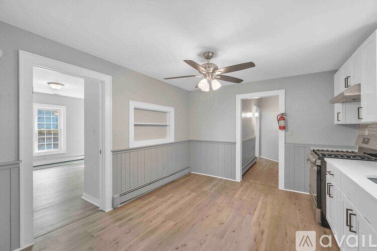 A kitchen with a fan on the ceiling and a window.
