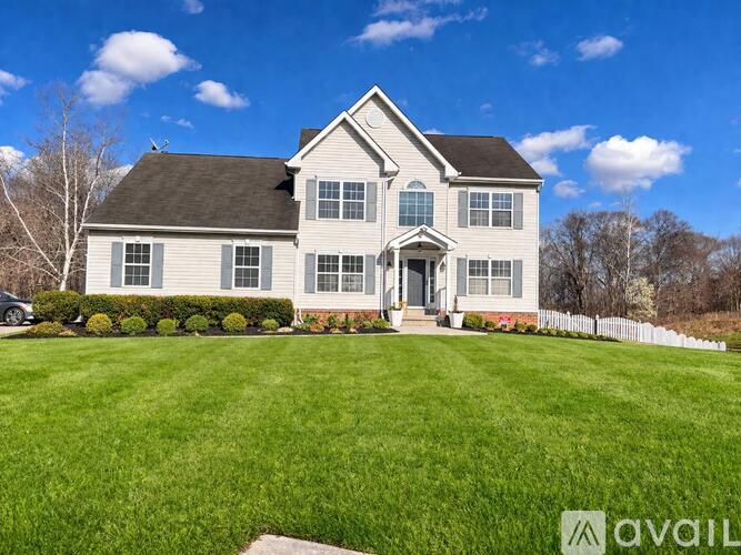 A large house with a white picket fence in front.