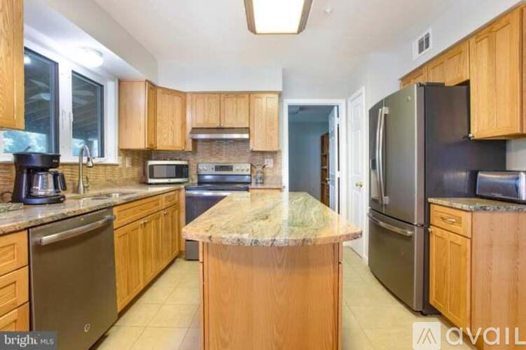 A kitchen with wooden cabinets and a granite countertop.