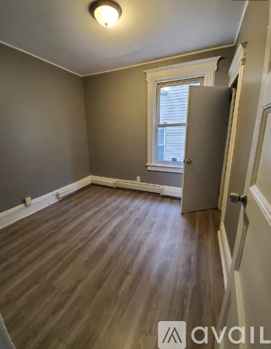 A room with wooden flooring and a window.