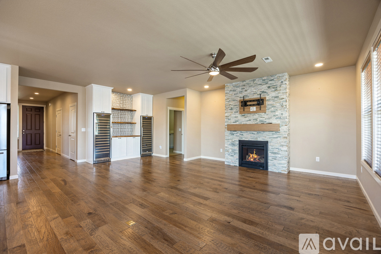A spacious room with a fireplace and a fan on the ceiling.