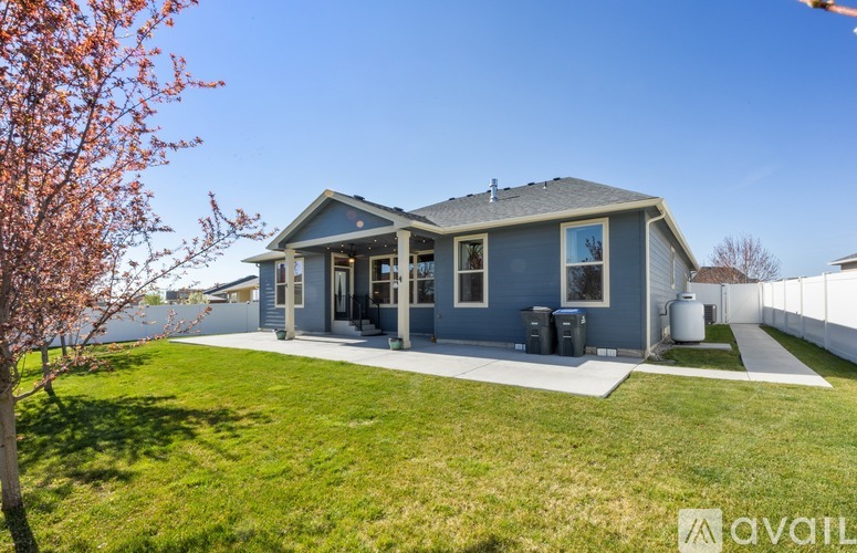 A house with a blue exterior and a white fence is for sale.
