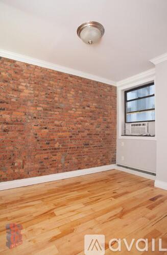 A room with a brick wall and wooden floor.