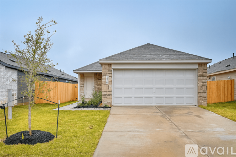 A house with a white garage door and a brown fence.