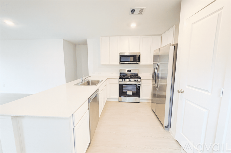 A kitchen with white cabinets and appliances.