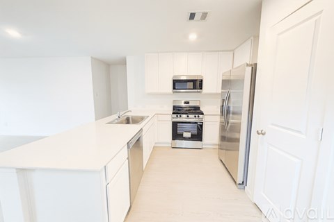 A kitchen with white cabinets and appliances.