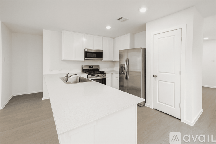A kitchen with white cabinets and appliances is available for rent.