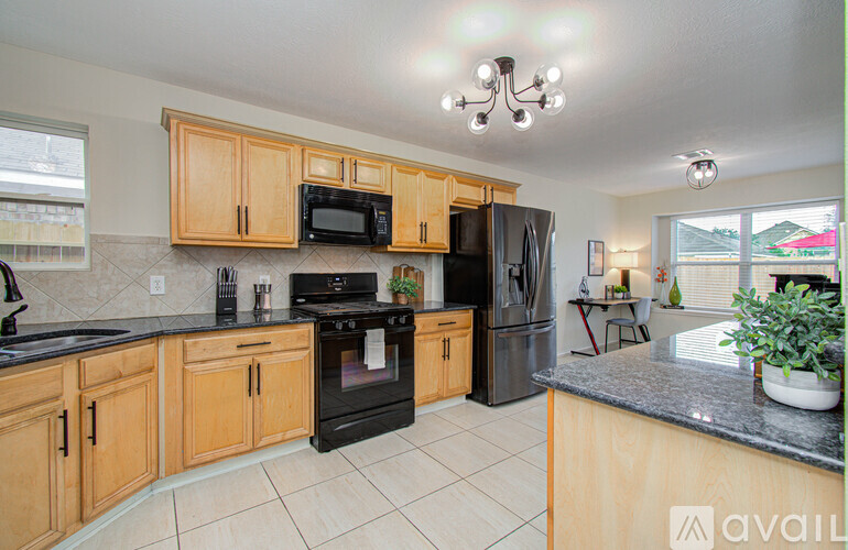 A kitchen with wooden cabinets and black appliances.