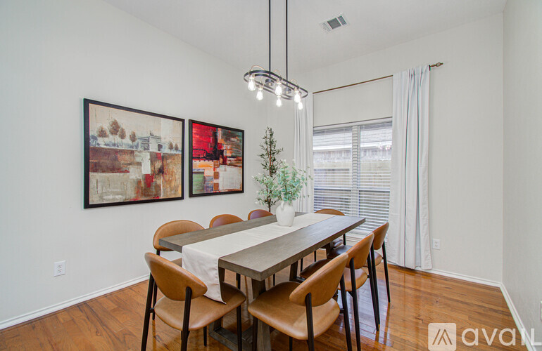 A dining room with a wooden table and chairs.