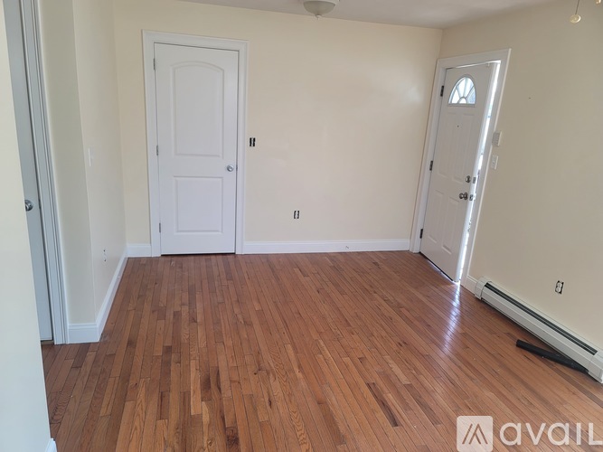 A room with wooden floors and two doors.