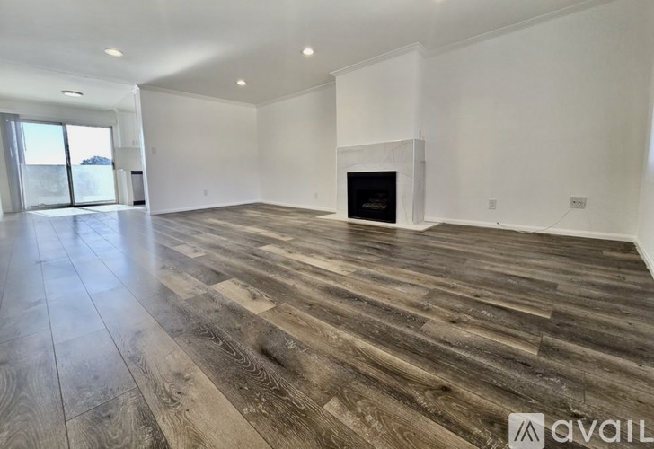 A spacious living room with a fireplace and wooden flooring.