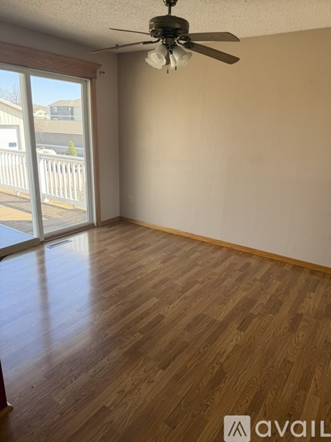 A room with wooden flooring and a ceiling fan.