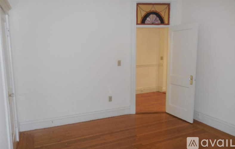 A room with a wooden floor and a white door.