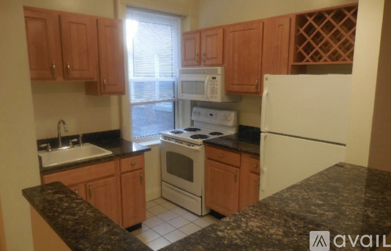 A kitchen with wooden cabinets and a granite countertop.