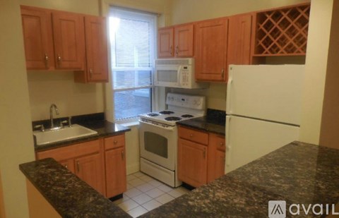 A kitchen with wooden cabinets and a granite countertop.