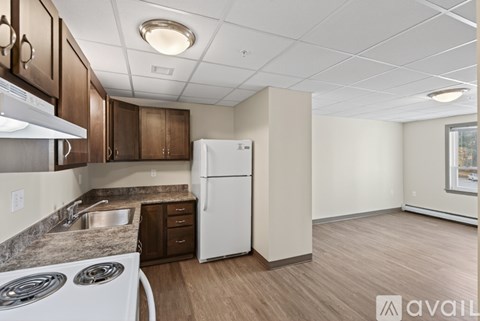 A kitchen with a white fridge and a stove top oven.