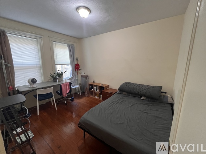 A bedroom with a bed, desk, and chair.
