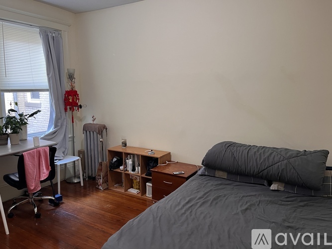 A bedroom with a bed, desk, and chair.