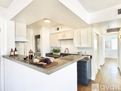 A kitchen with white cabinets and a granite countertop.