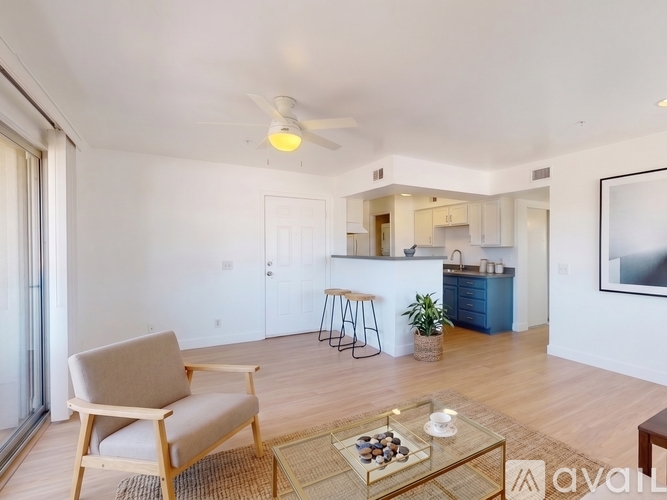 A living room with a chair, a table, and a ceiling fan.