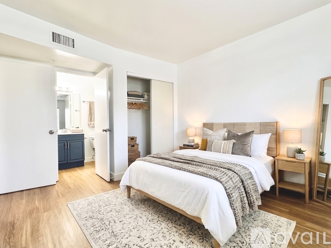 A bedroom with a large bed and a wooden floor.