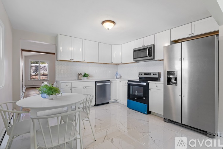A kitchen with a table and chairs and a fridge.