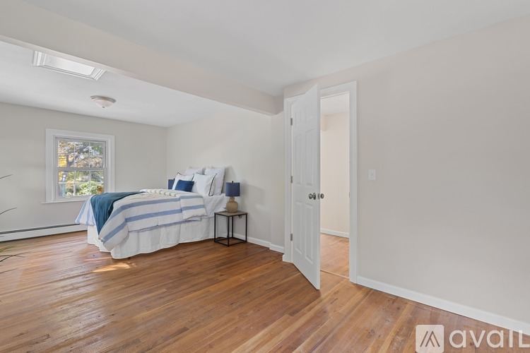 A bedroom with a bed and a window.