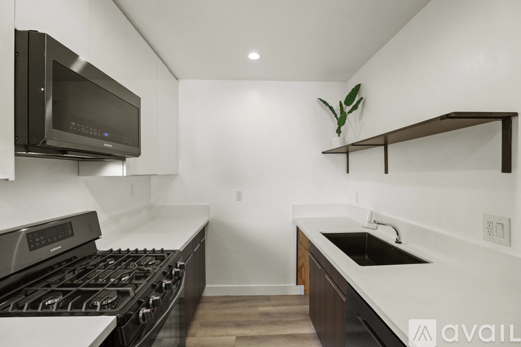 A kitchen with a black stove top oven and a black microwave.