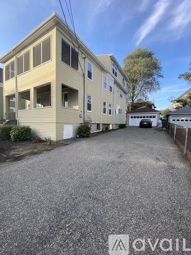 A gravel driveway leads to a two-story building with a garage.