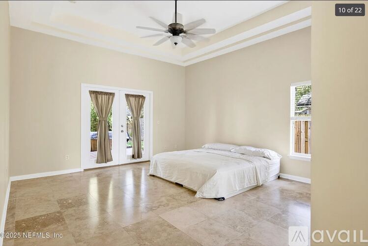 A bedroom with a large bed and a ceiling fan.