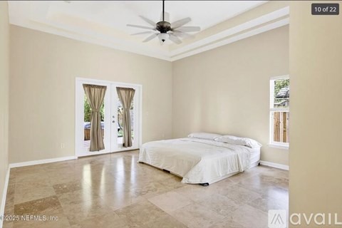 A bedroom with a large bed and a ceiling fan.