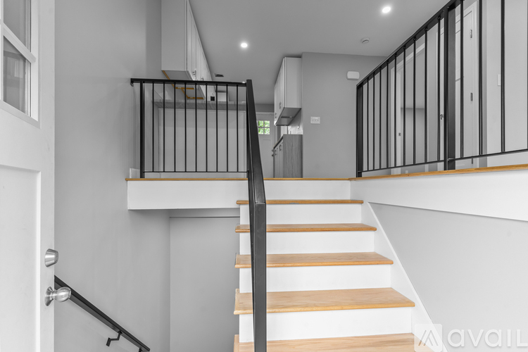 A staircase with wooden steps and a black metal railing.