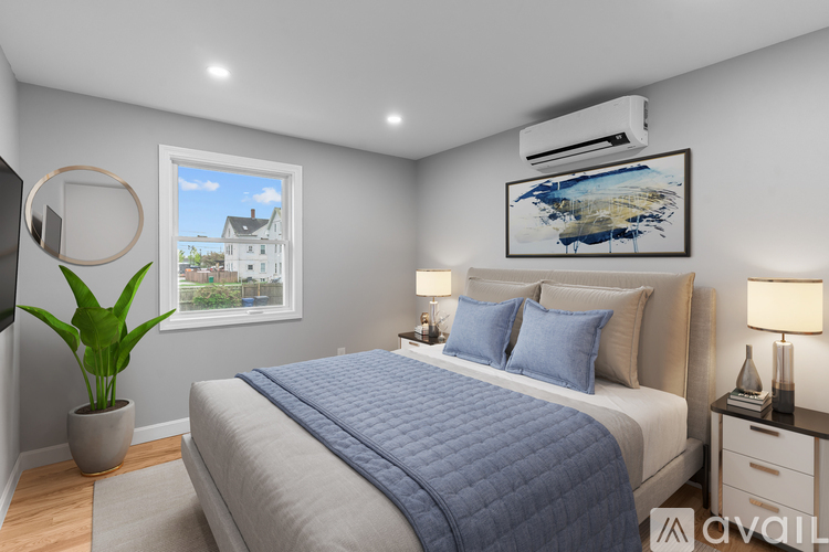 A bedroom with a large bed and a window overlooking a house.