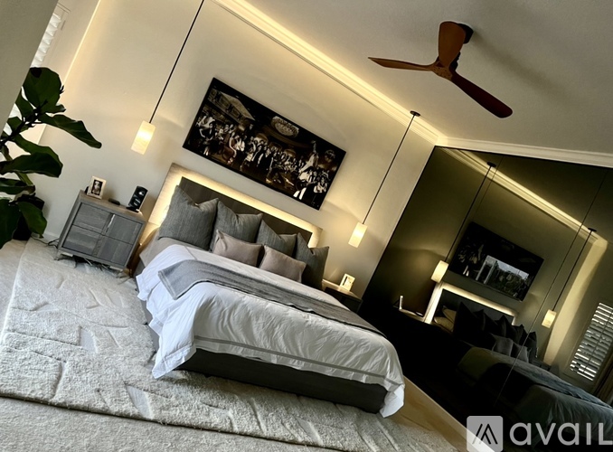 A bedroom with a large bed and a ceiling fan.