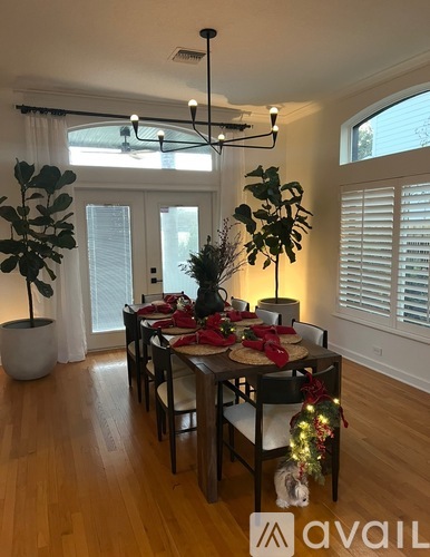 A dining room with a table set for a meal and a dog under the table.