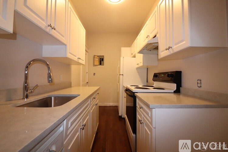 A kitchen with white cabinets and a stainless steel sink.