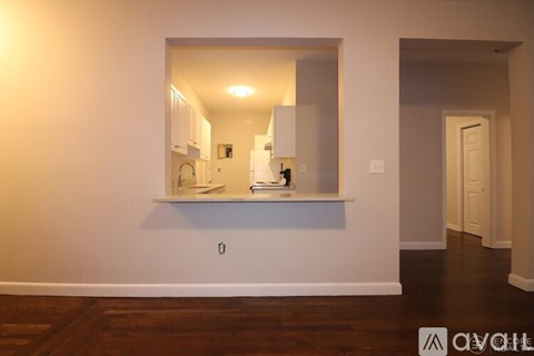A kitchen with white cabinets and a wooden floor.