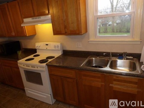 A kitchen with a white stove top oven and a sink.
