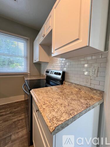 A kitchen with a granite countertop and a stove top oven.
